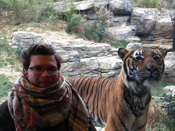 Gunner Maness, designer at Code & Color, sitting next to a Bengal tiger